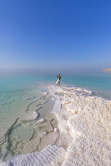 Blonde young woman in a long skirt on the shore of the dead sea. Jordan