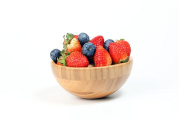 Strawberry blueberry in wooden bowl on white background