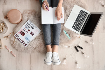 Female beauty blogger with notebook and laptop indoors, top view
