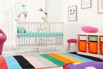 Colorful baby room interior with comfortable crib