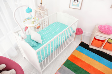 Colorful baby room interior with comfortable crib