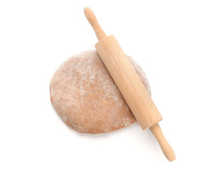 Raw rye dough and rolling pin on white background, top view