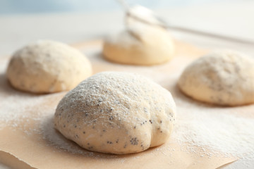Fototapeta na wymiar Fresh raw dough with poppy seeds and flour on table