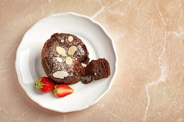 Plate of delicious fresh fondant with hot chocolate and strawberries on table, top view. Lava cake...
