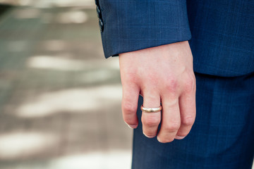 Wedding ring on a man's arm with a close-up jacket