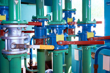 Several valves on the pipeline painted with green paint. Abstract background.