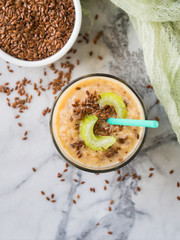 Smoothie with fennel, apple, carrots, celery and flax seeds on marble table background