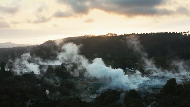 Wide drone shot Te Puia geysers at sunset, Rotorua.