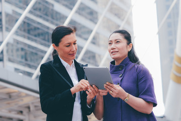 Two business woman talking together at outdoor.