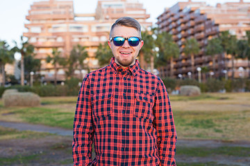 Happy guy looking sunset on background park and buildings