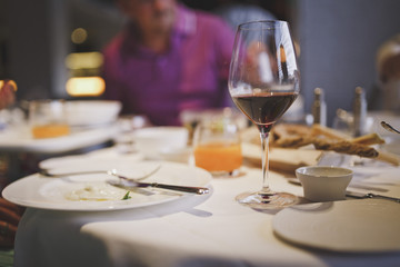 Meals are served at the restaurant. On the table there is red wine in the glass, cutlery and plates in the process of eating. Life style.