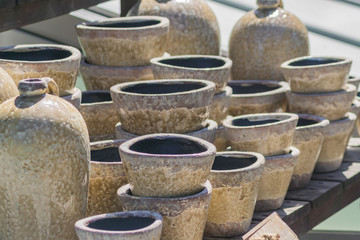 clay flower pots and vases stucked on wooden table in the garden.