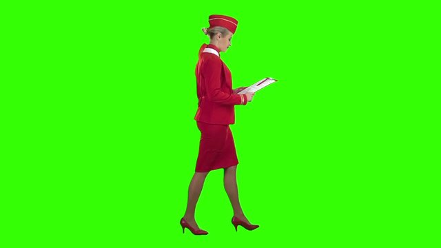 Woman steps with a red folder in her hands . Green screen. Side view. Slow motion
