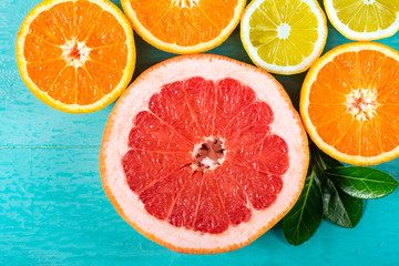 Sliced grapefruit, oranges and lemon. Citrus fruits collection on blue wooden background