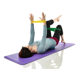 Woman exercising doing postnatal workout. Female fitness instructor working out with a rubber...