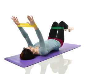 Woman exercising doing postnatal workout. Female fitness instructor working out with a rubber...