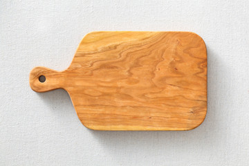 Cherry wood cutting board on linen, handmade wood cutting board