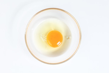 Raw Egg Yolk and white liquid in transparent glass bowl white background