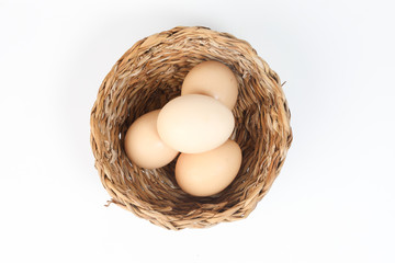Eggs in a nest basket on white background