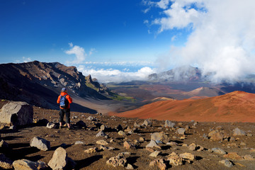 Tourist hiking in Haleakala volcano crater on the Sliding Sands trail. Beautiful view of the crater floor and the cinder cones below. Maui, Hawaii © MNStudio