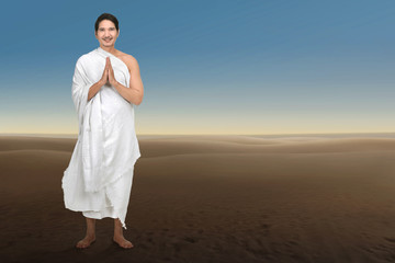 Smiling asian hajj man with ihram cloth praying