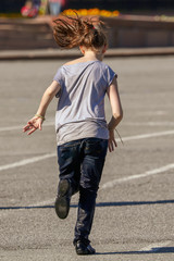 Fototapeta premium The girl is running on the asphalt
