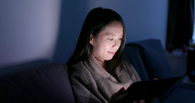 Woman use of tablet computer at home in the evening