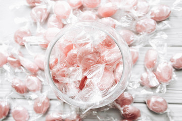 Pile of small pink sugar candies in glass