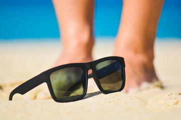 Fashion sunglasses on sea beach. Summer holiday relax background with copy space
