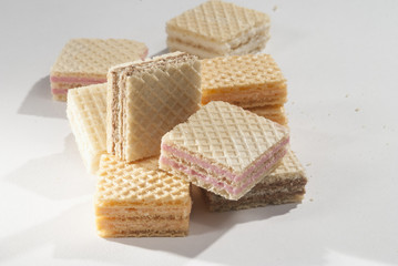 Wafer Cube shape biscuits with orange strawberry and chocolate flavor on a white background