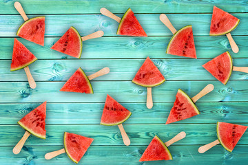 Watermelon slice popsicles on blue wood background, fresh summer fruit concept - Powered by Adobe