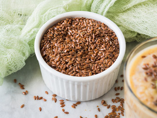 Flax seeds in white ramekin on marble board