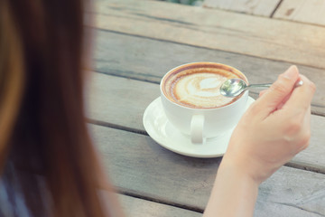 Women work, drink coffee, and use white notebooks on the table.
