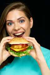 Young woman eating biting burger.