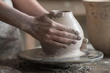 potter sculpts a vase on a potter's wheel