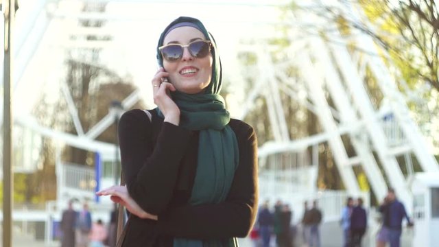 attractive woman in hijab and sunglasses talking on the phone
