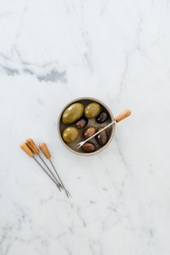Olives on a marble table.