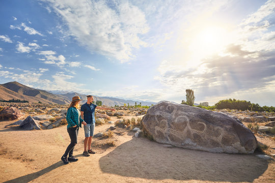 Couple of tourist near ancient stone painting