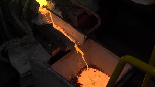Hot steel pouring at steel plant. In the frame, molten metal is poured through special channels, for the further rolling with a special machine. Modern metallurgical industry