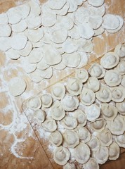Freshly cooked dumplings lying on a wooden board. Phone photography.
