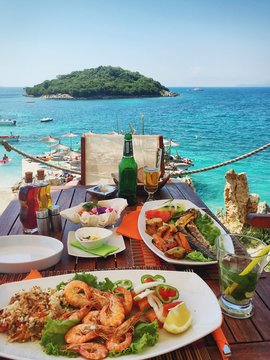 Fresh seafood on the table in summer cafe on the Mediterranean coast. Location famous place Ksamil beach, Saranda popular coastal Albanian resort, Albania, Europa. Beauty world. Mobile photography.
