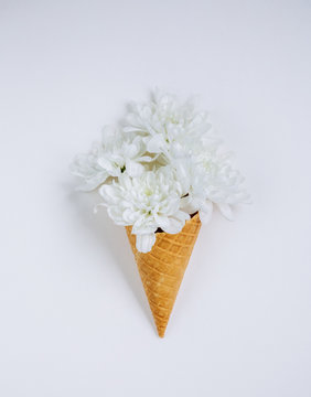 Lovely bouquet flower in ice cream cone on white background. Floral arrangement, flat lay styling. Top view.