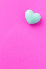 Turquoise heart shape over purple color table. Valentine Day concept.