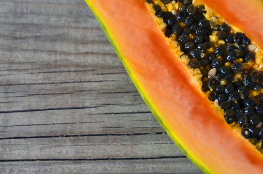 Fresh ripe organic papaya tropical fruit cut in half on old wooden background.
Healthy eating,diet or vegan food concept.Selective focus.