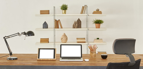 Laptop smartphone and tablet mockup with blank screen on table, office style. © UnitedPhotoStudio