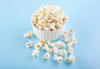 Popcorn on a bright blue background. Film. Fast food. Corn
