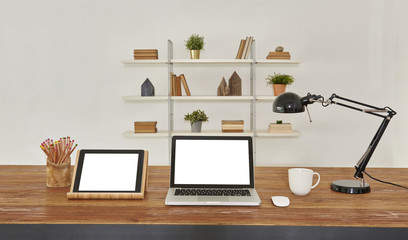 technological office and workplace interior style on the wood table. Tablet laptop and lamp decoration.