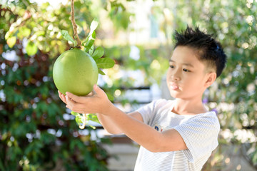 young boy with green fruit