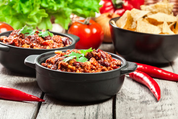 Bowls of hot chili con carne with ground beef, beans, tomatoes and corn