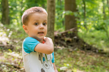 Portrait of boy against trees in forest 